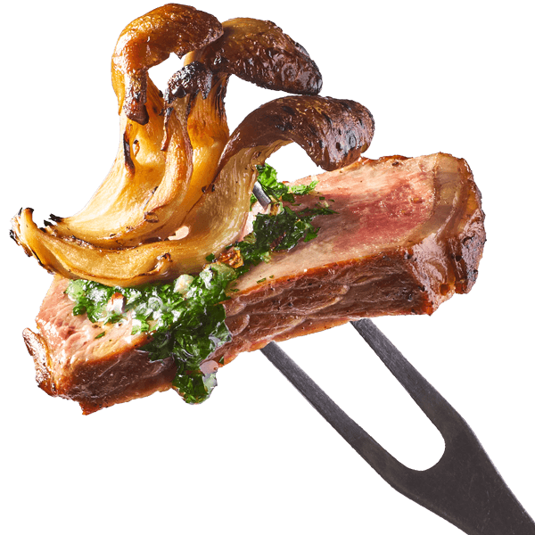 A bite of oyster mushrooms with steak and chimichurri sauce on the tip of a fork