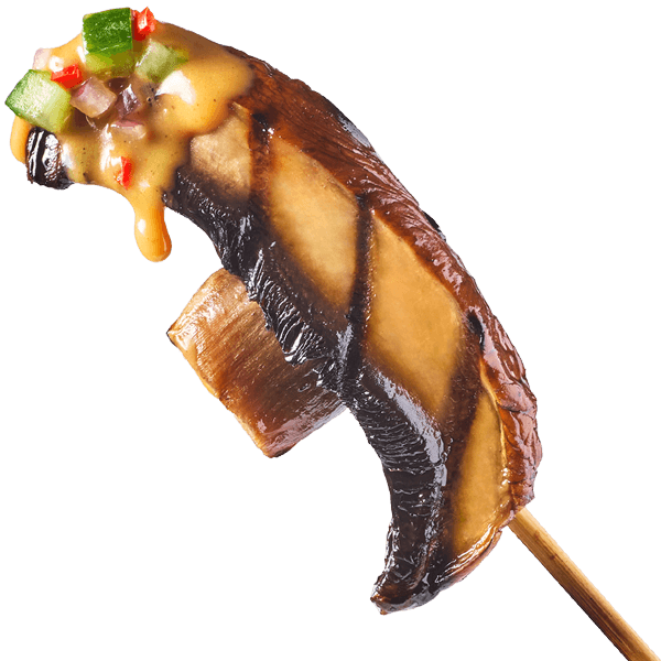 A bite of portabella satay with spicy cucumber relish and peanut sauce on the tip of a skewer